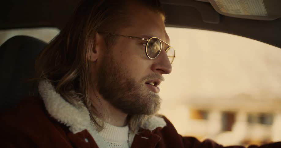 Man with glasses and beard drives