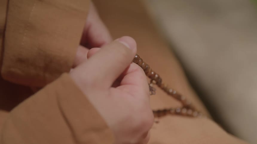 A persons hands holding a rosary