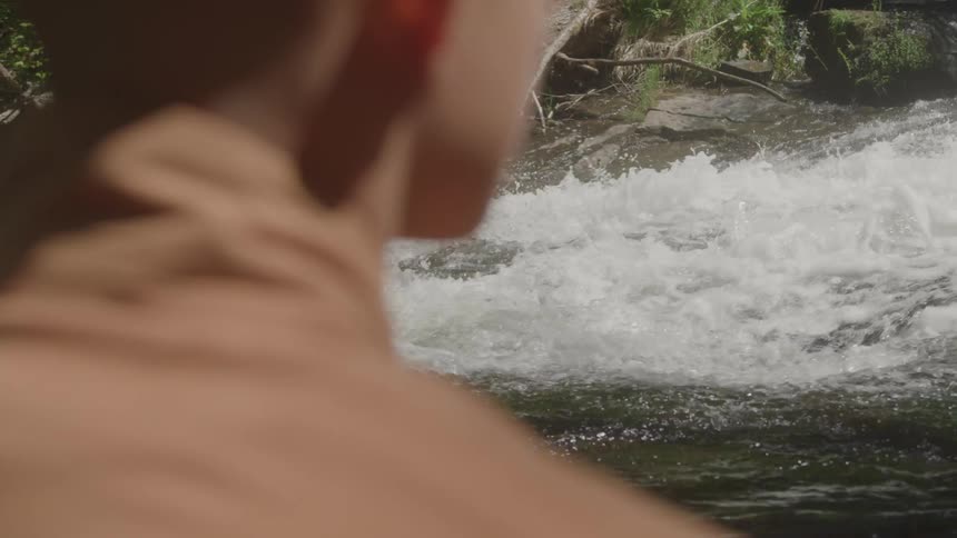 Person watching the river stream in the midst of nature