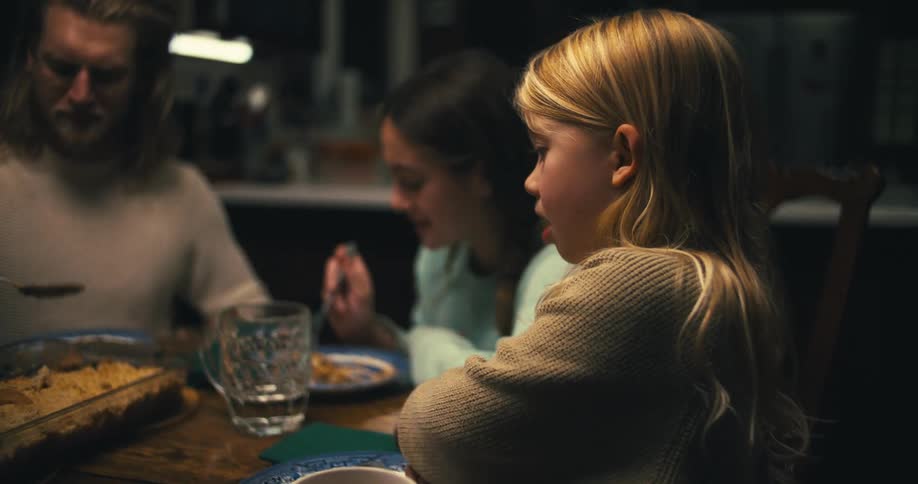 A family shares a quiet dinner together at the dining table