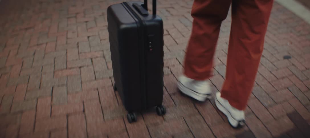 The woman rolls her luggage as she travels