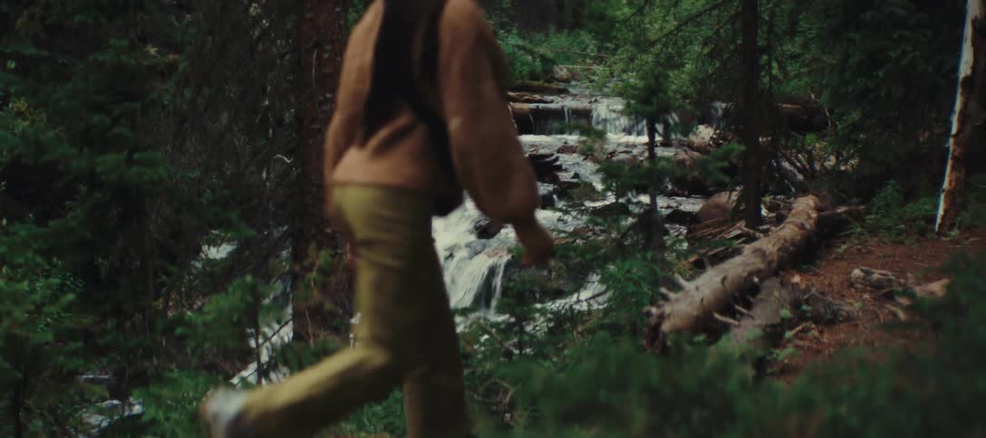 The woman hikes by the stream
