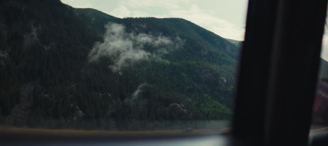 Mountains covered with forest seen through a vehicle window