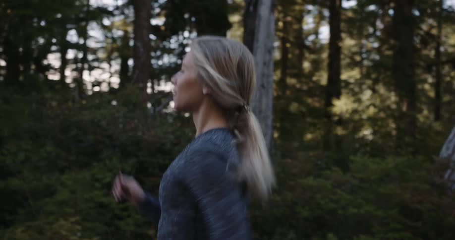 The woman is jogging in the forest