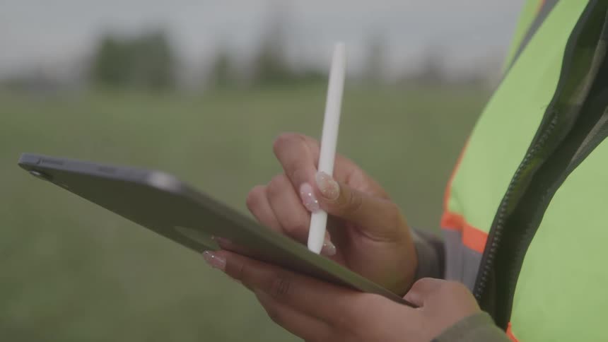 The worker is writing on a tablet with a stylus
