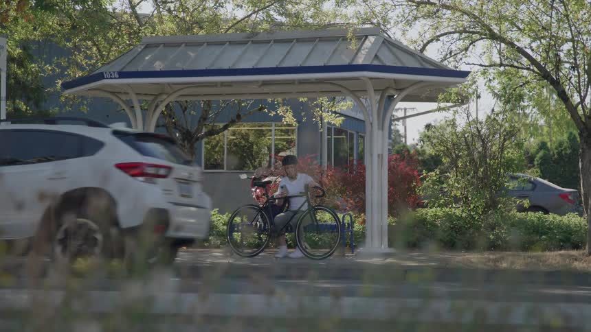 A woman with her bike is waiting for the bus