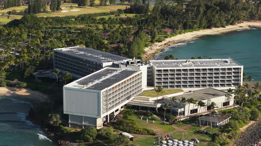 Large seaside resort complex seen from above along a sandy bay