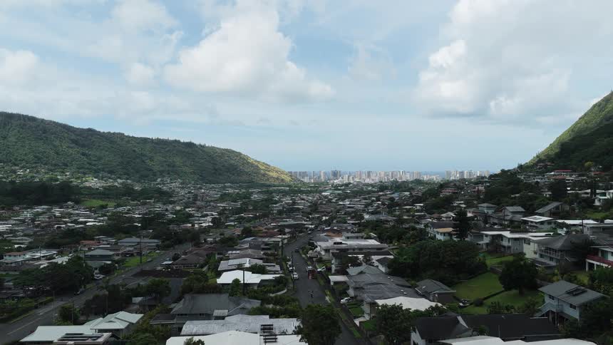 Aerial view of suburban neighborhood by green mountains