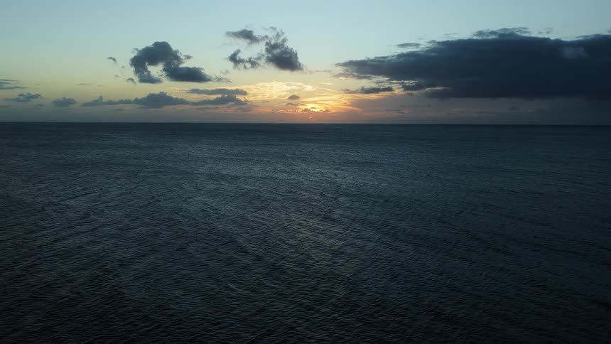 The sun sets over the ocean horizon