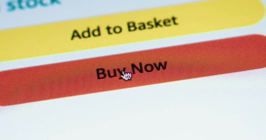 A cursor hovers over a bright orange buy now button on a computer screen with a yellow add to basket button visible above it