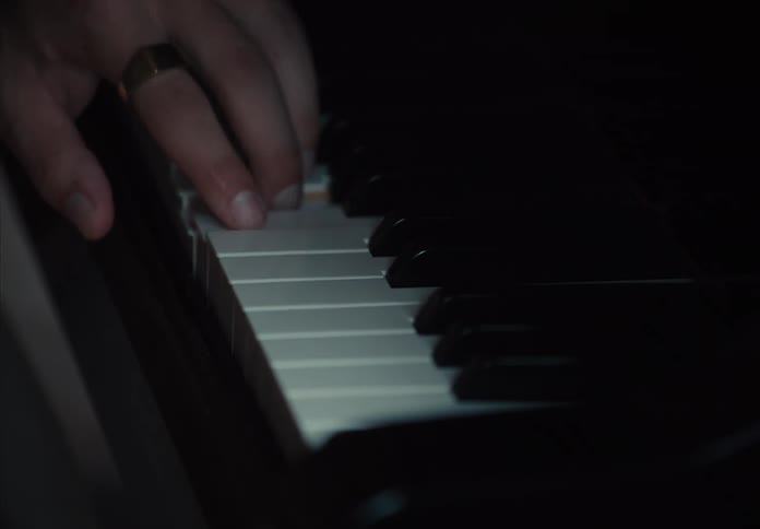 Person hand playing the white keys of a piano