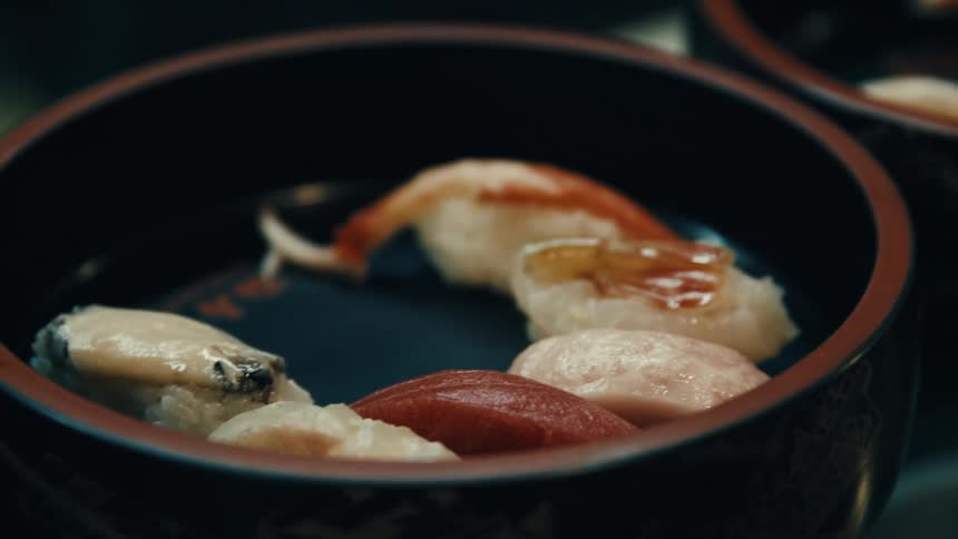 A closeup of assorted sushi in a traditional bowl
