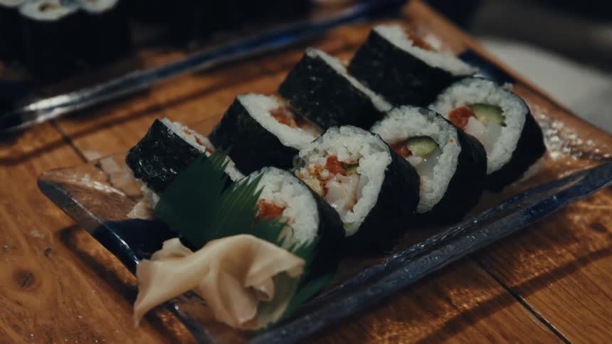 A small glass tray with sushi rolls