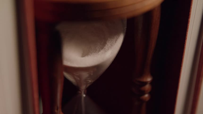 Sand pours down the hourglass