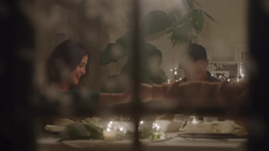 Smiling couple attends a candlelit dinner