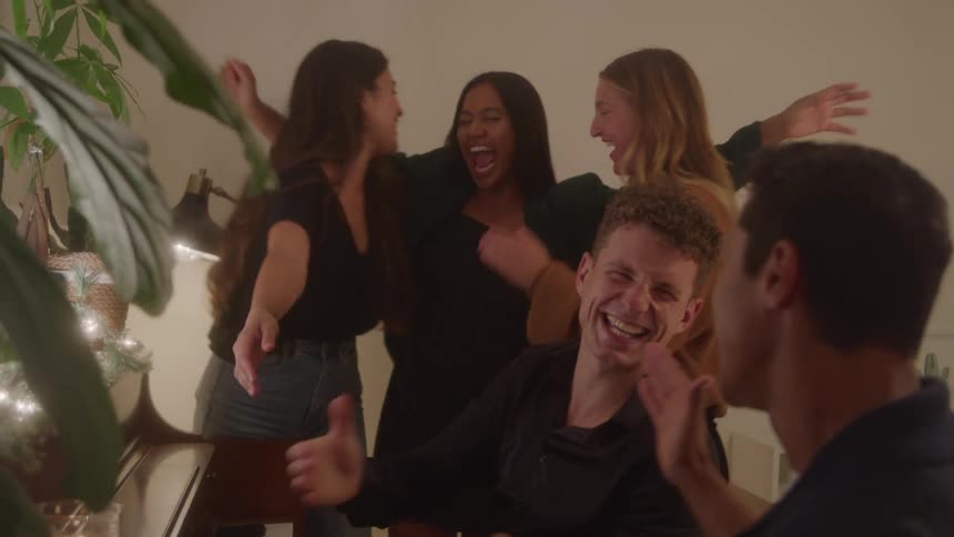 Group of friends laugh and hug in a moment of celebration