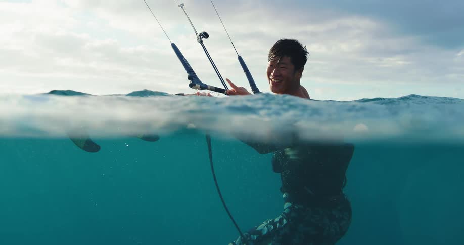 A man is smiling while kite surfing