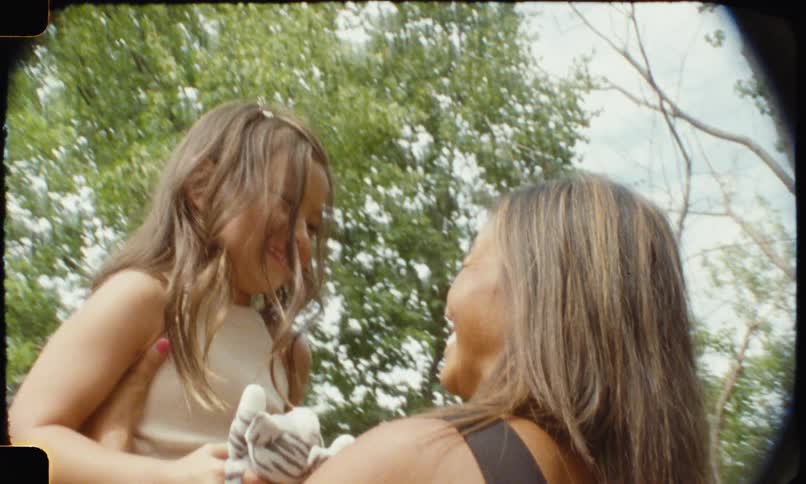A mother carrying her daughter in her arms lifting her up