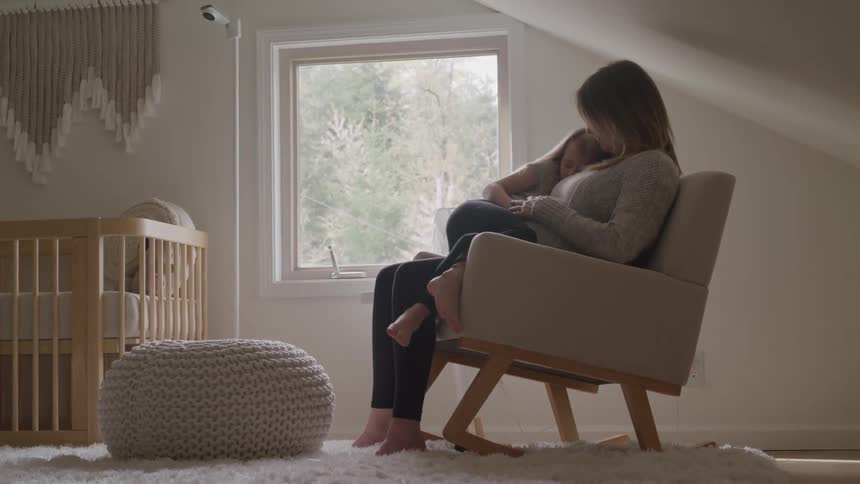 Woman resting on a chair with her child indoors during the day