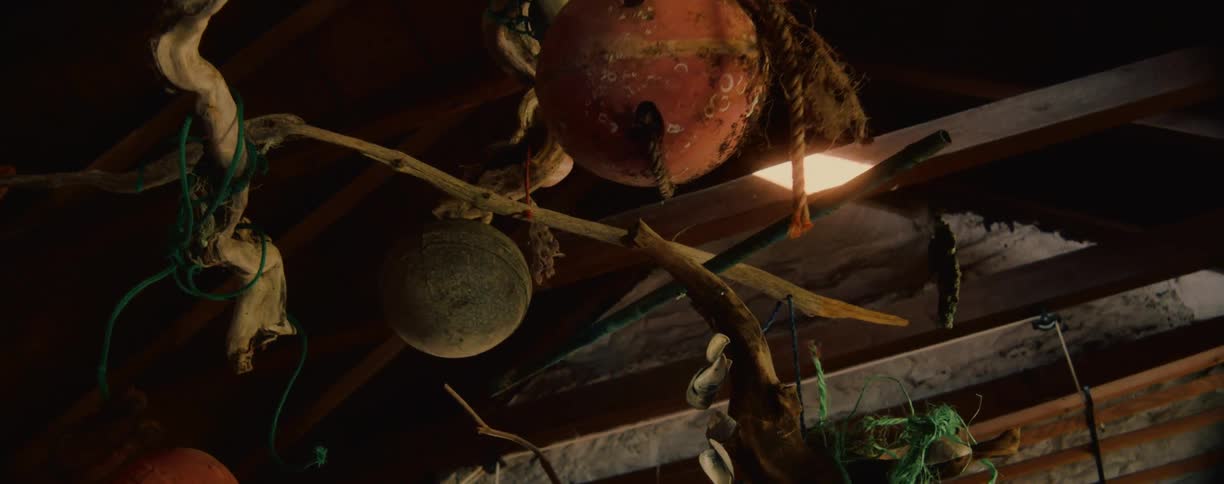 Rustic driftwood and buoy mobile hanging in a barn