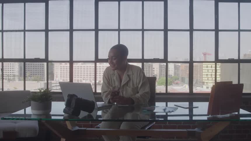 Person on a video call at a glass desk in a modern office