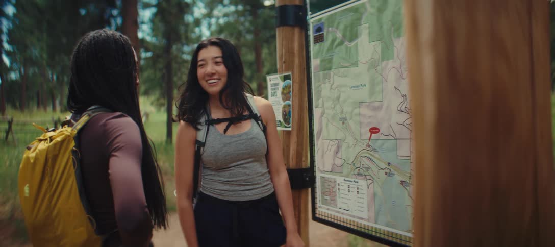 Two women look at a map before hiking in the park