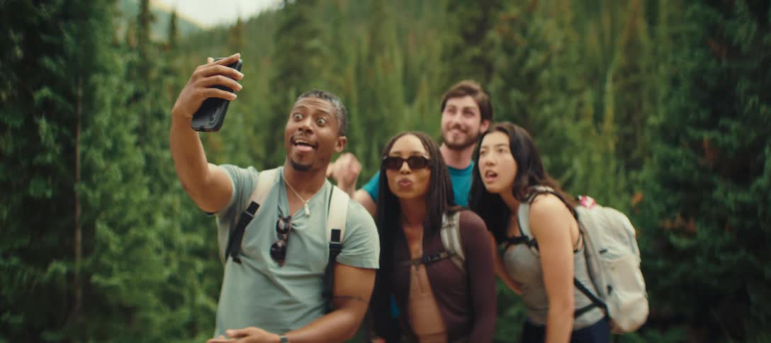 Friends acting silly while taking a selfie in the forest