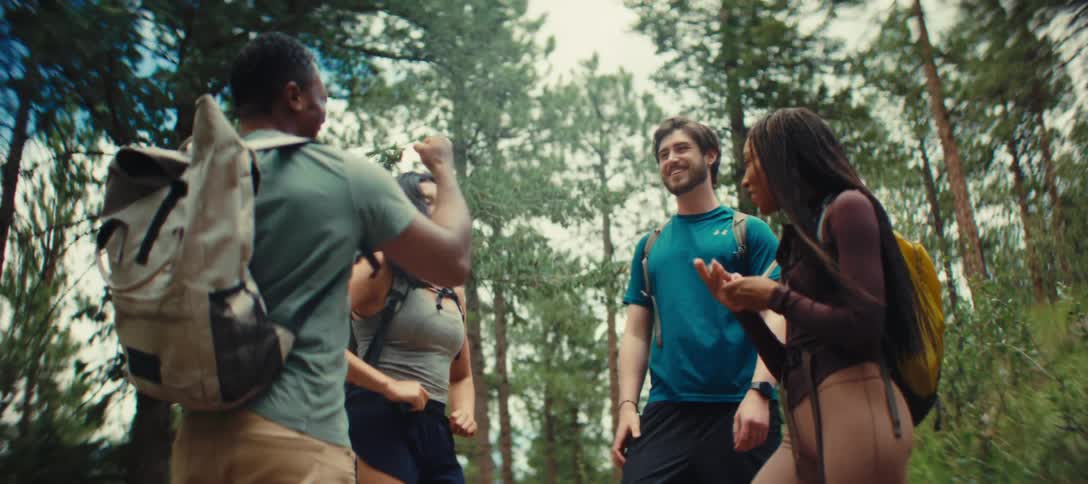 Group of friends hiking and laughing in a forest