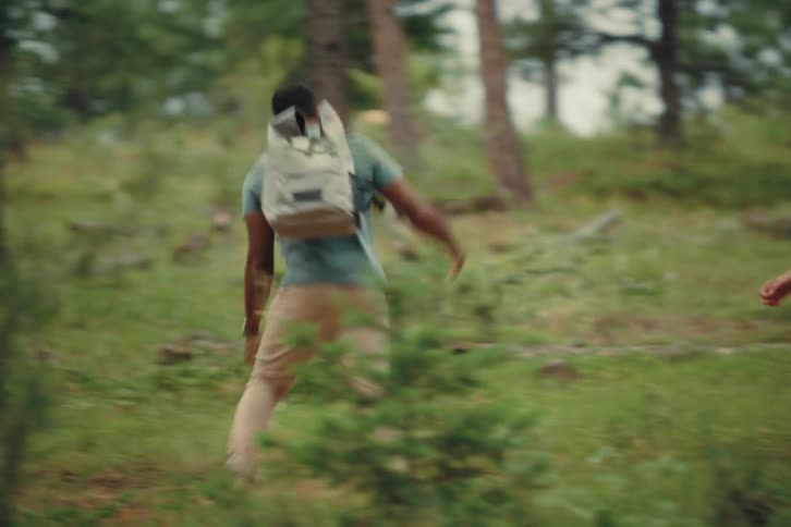 A group of friends is happily hiking through a forest