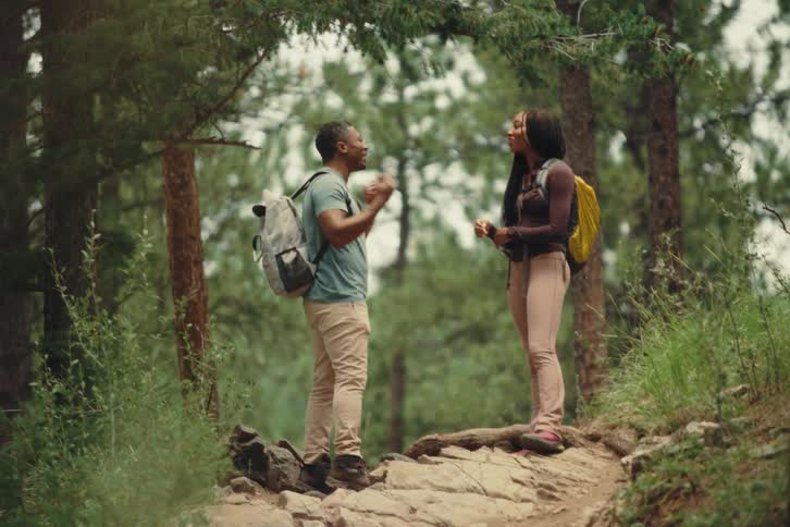 Two friends talk during a hike in the forest