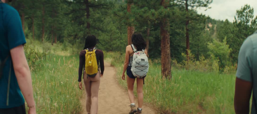 Group of friends walks along a trail surrounded by nature