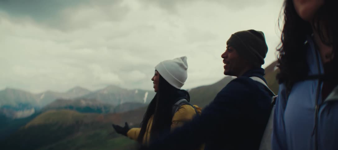 Hikers smile while walking through the mountains