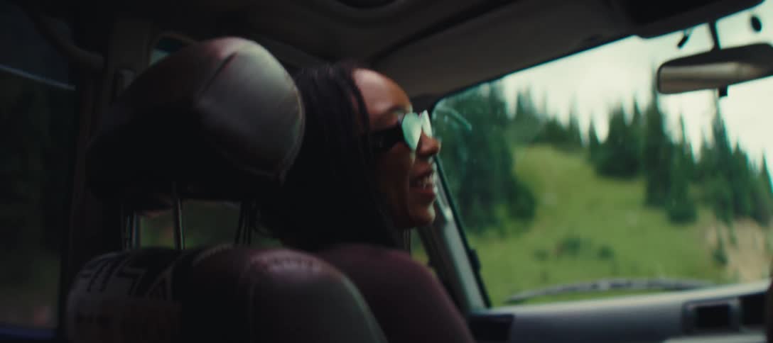 The woman laughs and talks while riding in the car