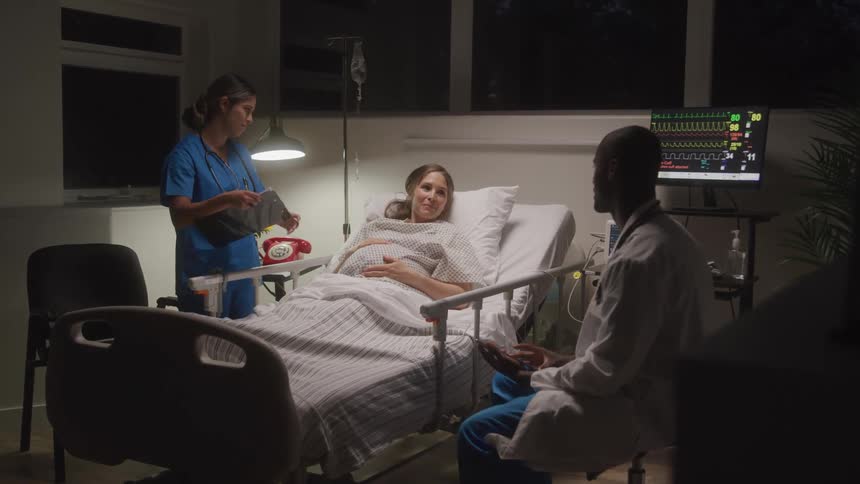 A doctor and nurse talk with a patient