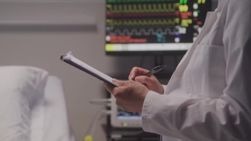 The doctor writes notes on the clipboard