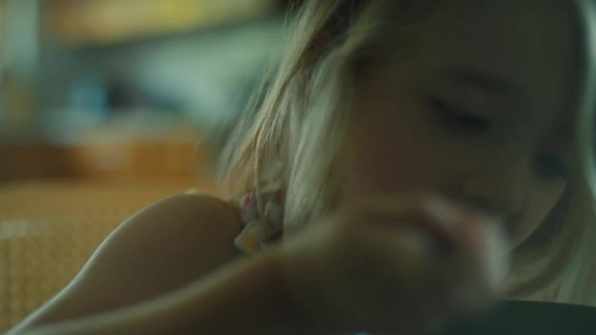 Young blonde girl sitting in the kitchen eats breakfast
