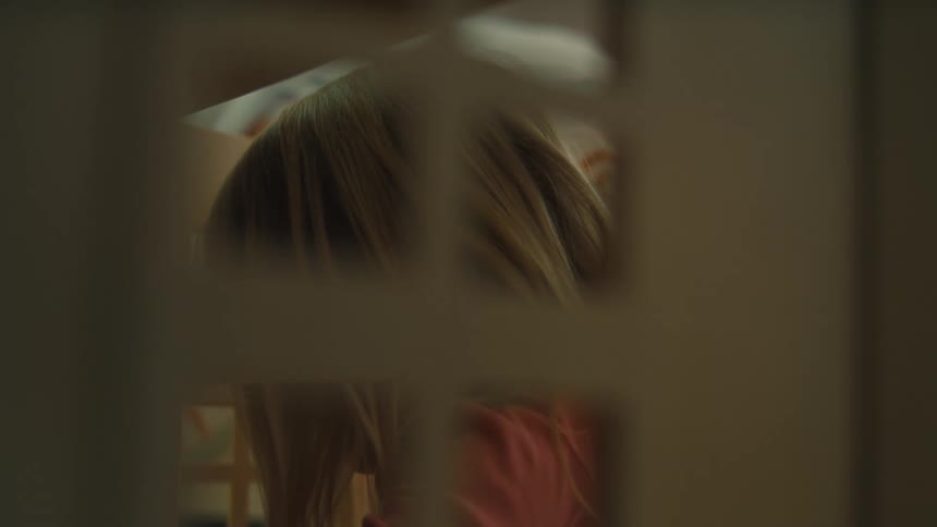 A young girl plays with a playhouse indoors