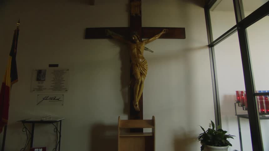 A crucifix with jesus is displayed inside a church or chapel