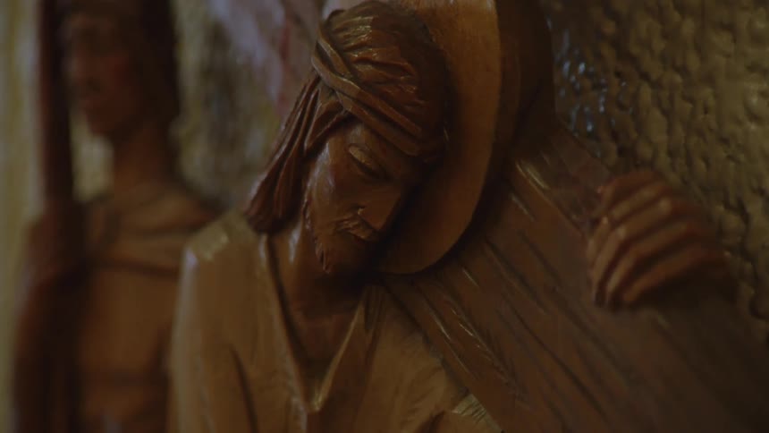 Wooden art of jesus carrying the cross