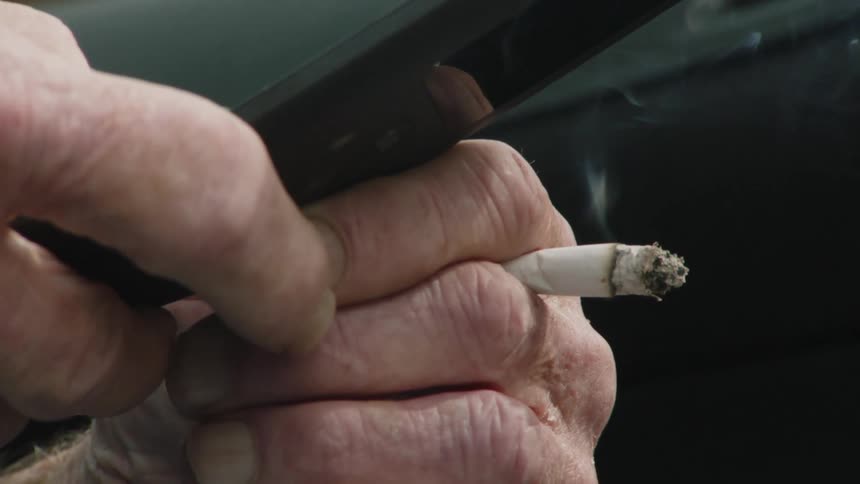 A mans hands are shown pushing buttons on an old flip phone