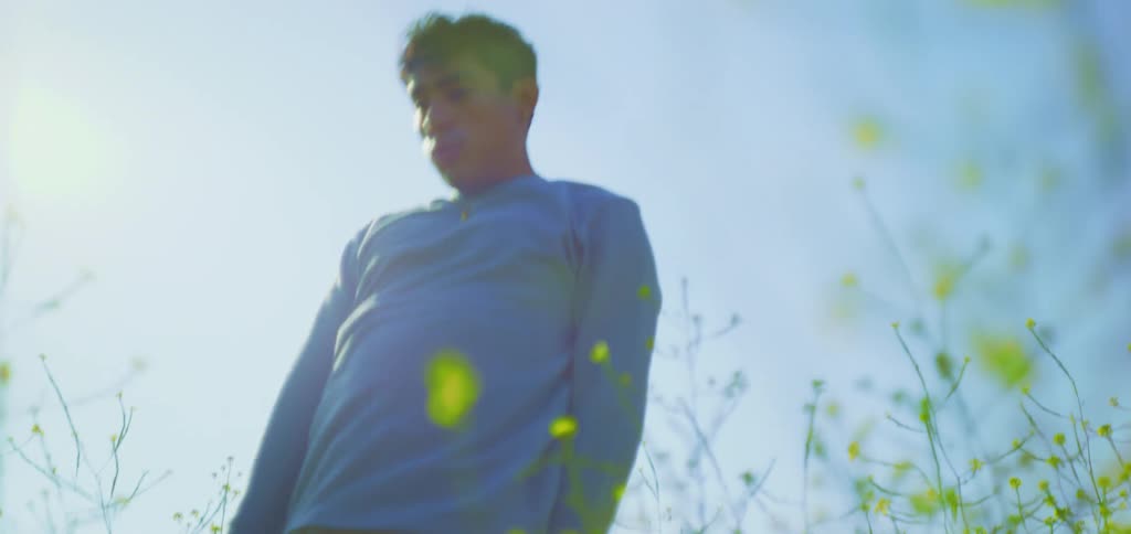 Man dancing in a field with yellow flowers
