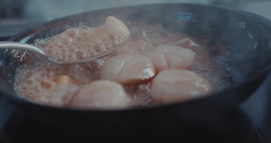 Food in sauce being prepared in a frying pan