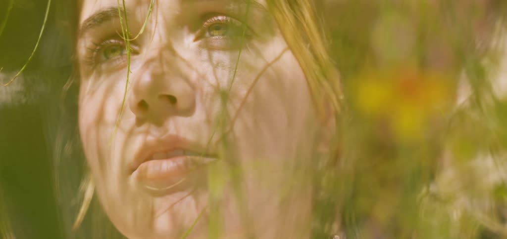 The woman is looking up at the bright sun