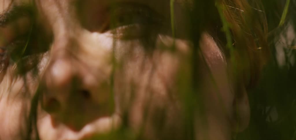 The leaves from the tree touch the womans face