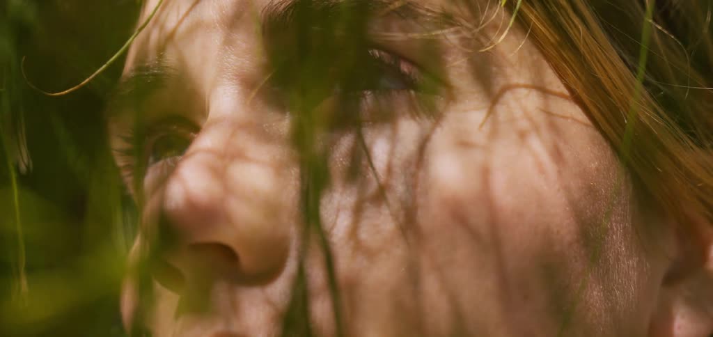 Portrait of a woman among green leaves during the day