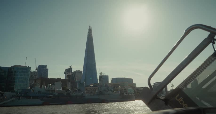 Shard skyscraper in london seen from the river with military ships nearby