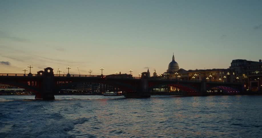 Bridge lit over the river thames at dusk with st pauls cathedral in the background