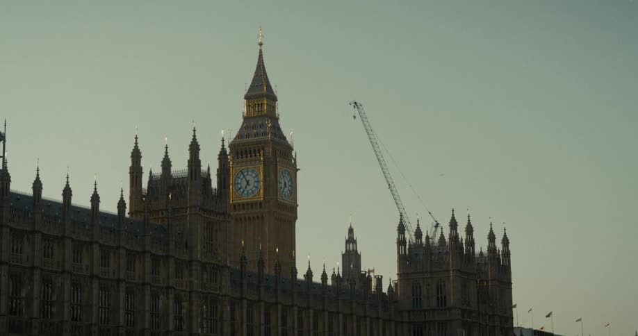 The video shows the palace of westminster in london england viewed from across the river thames the iconic big ben clock tower is visible with a construction crane behind it