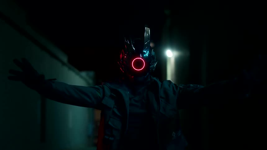 A masked figure performs a film action scene in the dark