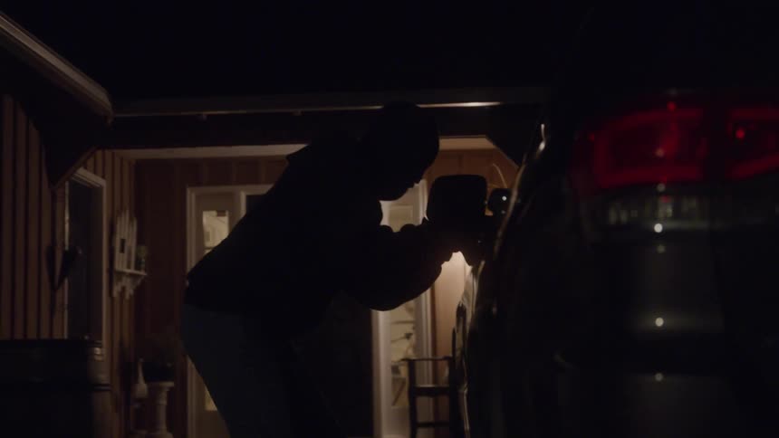 A man breaks into a vehicle in a home driveway and gets inside